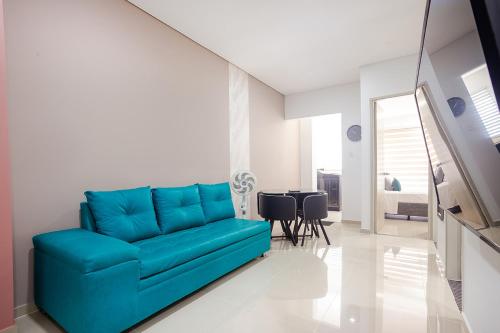 a blue couch in a living room with a table at Montepinares Apartaestudios in Montería