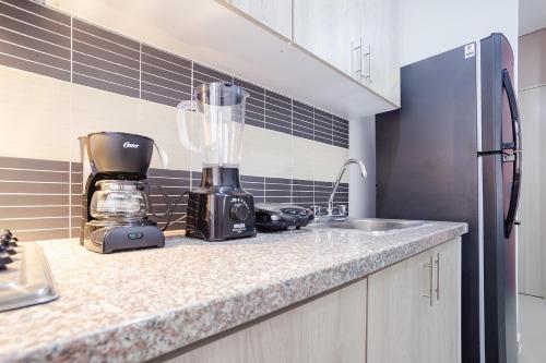 a kitchen counter with a blender and a sink at Montepinares Apartaestudios in Montería