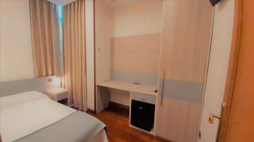 a small bedroom with a bed and a desk at Hotel Nueva Plaza in Maliaño
