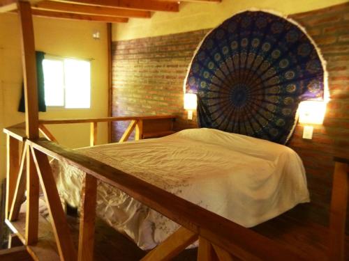 a bed in a room with a brick wall at Cabaña Cafuné in El Bolsón