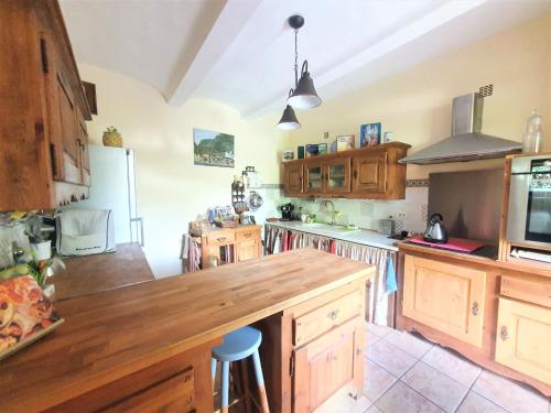 a kitchen with wooden cabinets and a large wooden counter top at Mes Maisons Gardoises, Two Gites sleeping 13 with Two Private pools, Kids Room, Laundry, Disco, free WiFi, Linen and Dog's are Welcome in Gagnières