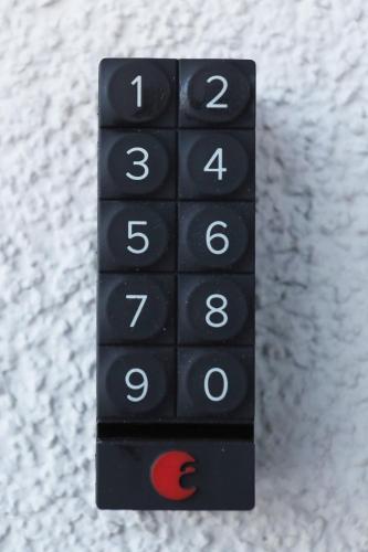 a black remote control sitting on top of a bed at River Park apartments Ukmerge in Ukmergė