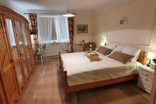 a bedroom with a large bed with a table on it at ZENDA - Przytulny apartament w zacisznym miejscu in Wieprz