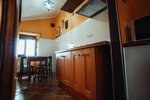 a kitchen with wooden cabinets and a table in it at Apartamentos Rurales Los Galpones in Coaña