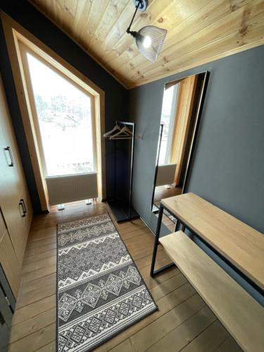 a room with a table and a window and a rug at Girske Povitria 2 in Yaremche