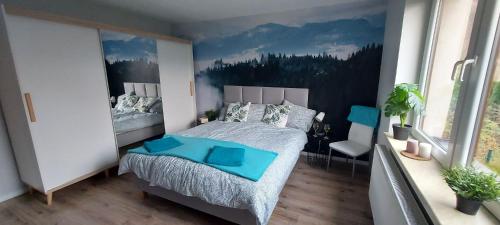 - une chambre avec un grand lit et une peinture murale dans l'établissement APARTAMENTY MONTANIA WISŁA, à Wisła