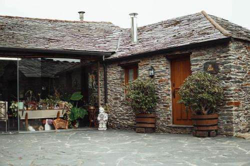 a dog standing in front of a stone house at Apartamentos Rurales Los Galpones in Coaña