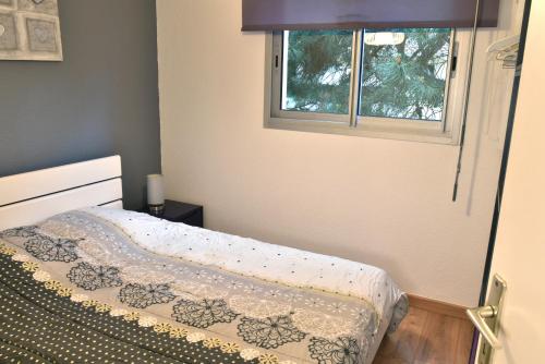 een kleine slaapkamer met een bed en een raam bij Le Byblos 9 - Vue Mer - Climatisation in Plage dʼArgelès