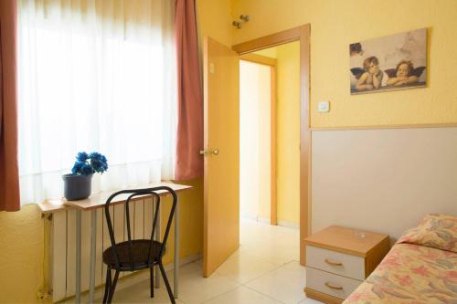a room with a bed, chair and a window at Hostal Alhambra Tarragona in Tarragona