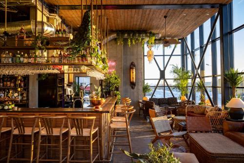 a restaurant with a bar with chairs and tables at The Greenhouse Hotel in Hveragerði