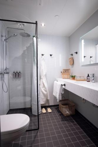 a bathroom with a shower and a toilet and a sink at The Greenhouse Hotel in Hveragerði
