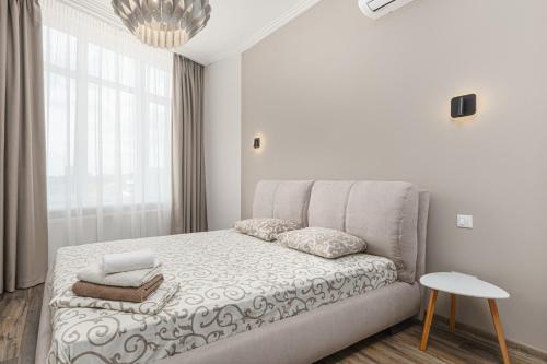 a white bedroom with a bed and a window at Sea Symphony 2-bedrooms Apartment in Odesa