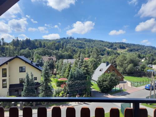 a view from a balcony of a village with a mountain at Willa Cyprys - pokoje i apartamenty z aneksami - Centrum in Wisła