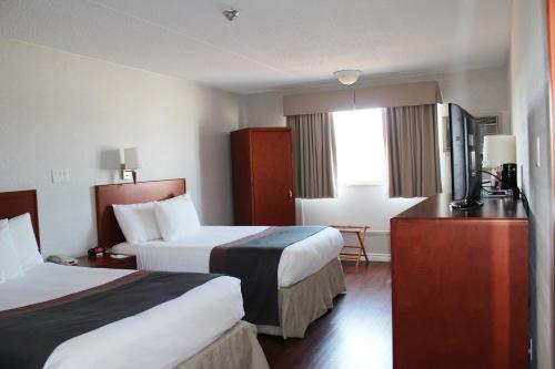 a hotel room with two beds and a television at Days Inn by Wyndham Bridgewater Conference Center in Bridgewater