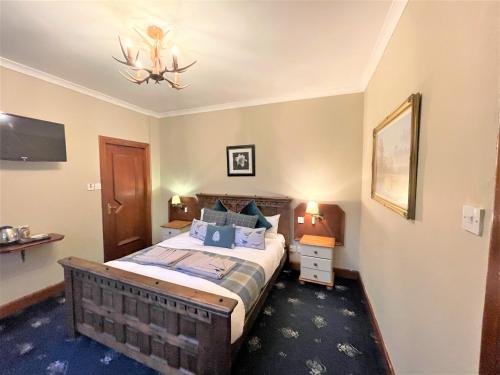 a bedroom with a bed and a chandelier at Dalgarven spa venue in Kilwinning