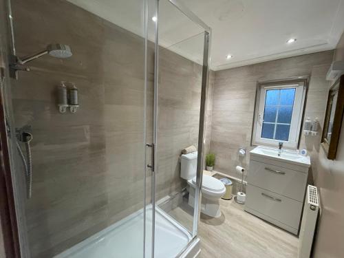 a bathroom with a shower and a toilet and a sink at Dalgarven spa venue in Kilwinning