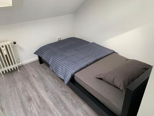 um pequeno quarto com uma cama e um radiador em Gemütliche Ferienwohnung bei Hamburg em Reinbek