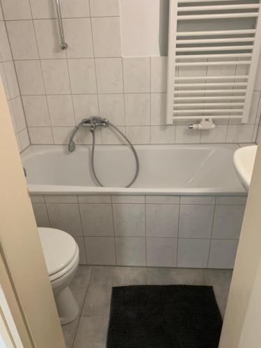 a bathroom with a toilet and a shower in a tub at Gemütliche Ferienwohnung bei Hamburg in Reinbek