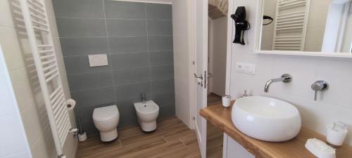 a bathroom with a sink and two toilets in it at Appartamenti Mascagni in Sannicandro di Bari