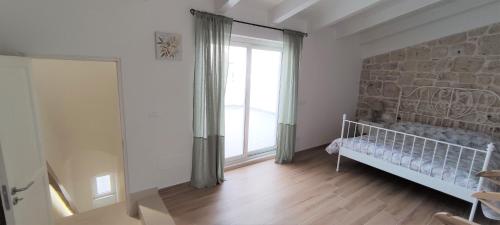 a white room with a crib and a large window at Appartamenti Mascagni in Sannicandro di Bari