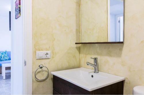 a bathroom with a sink and a mirror at Tranquilo apartamento. Piscina, playa y relax. in Sa Caleta