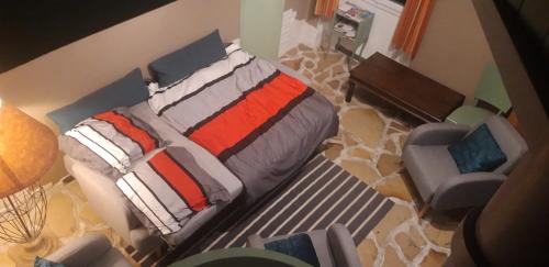 - une chambre avec un lit et une chaise dans l'établissement Gîtes chez Daniel 