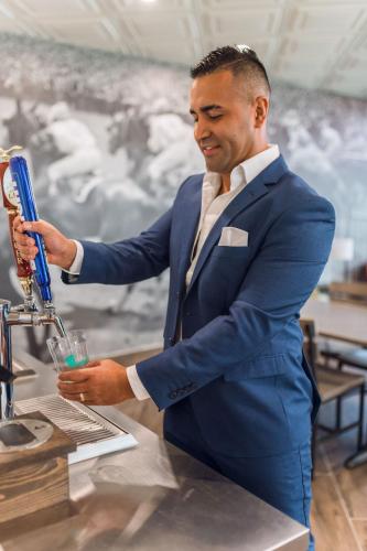a man in a blue suit holding a drink at Equus Inn I75 in Ocala