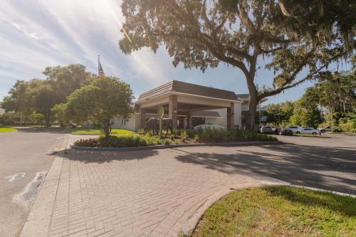 a building with a tree in front of a street at Equus Inn I75 in Ocala