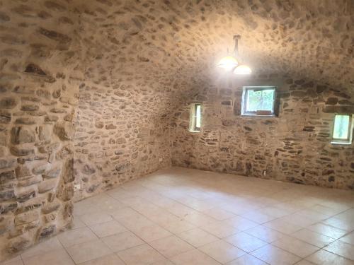 a large room with a stone wall and a light at Mes Maisons Gardoises, Two Gites sleeping 13 with Two Private pools, Kids Room, Laundry, Disco, free WiFi, Linen and Dog's are Welcome in Gagnières