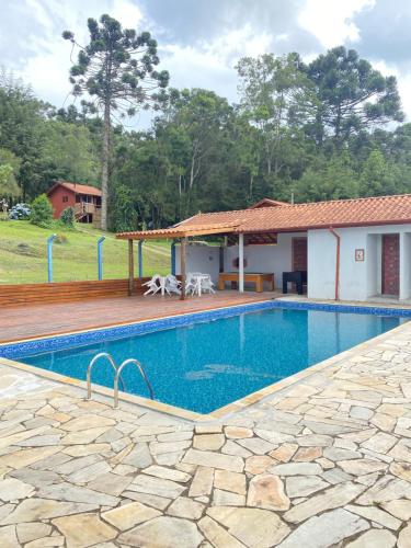 a swimming pool in front of a house at Residencial das Araucárias in Gonçalves