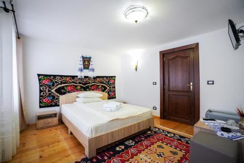 sypialnia z łóżkiem i drewnianymi drzwiami w obiekcie Casa Luca w mieście Vişeu de Jos