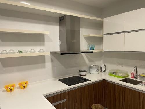 a kitchen with white cabinets and a stove top oven at Setia Sky 88 Living in the Skies in Johor Bahru