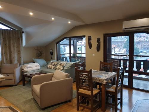 ein Wohnzimmer mit einem Sofa und einem Tisch in der Unterkunft Apartments Elegance in Bansko