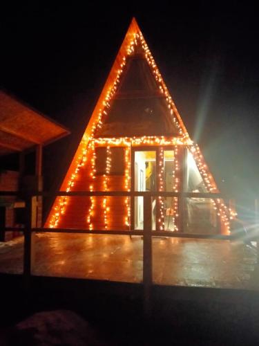 a pyramid house with lights on it at night at Popasul Dacilor in Predeluţ