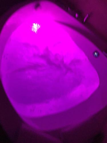 a purple lighted bathtub with a purple floor at Luxury Apartment with Jacuzzi in Santiago de Compostela