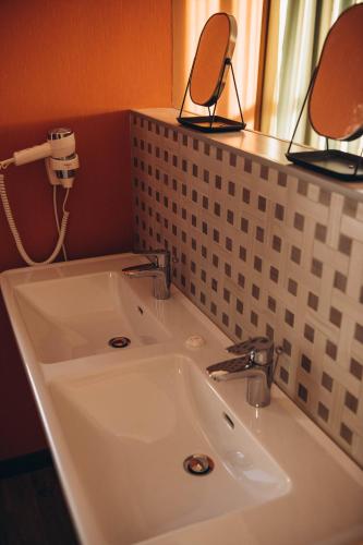 a bathroom with a sink and two mirrors on a counter at Дбайлива Ципа in Mizhhirʼʼya