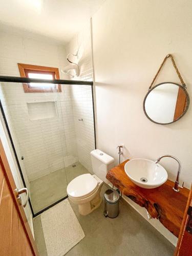 a bathroom with a toilet and a sink and a mirror at Pousada Brisa Mar in Fernando de Noronha