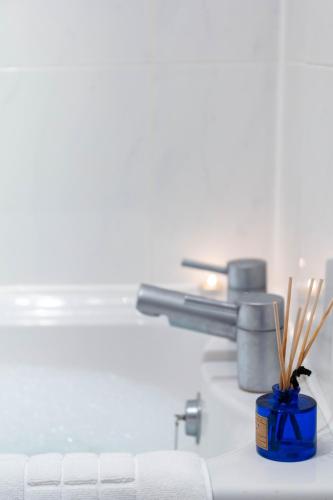 a bathroom counter with a blue container with wooden sticks at Turnberry accommodation in Turnberry