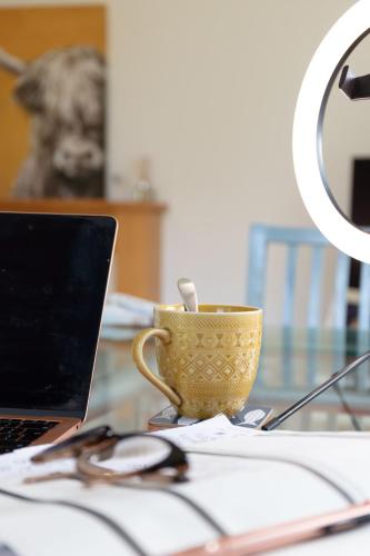 a table with a laptop and a cup on it at Turnberry accommodation in Turnberry