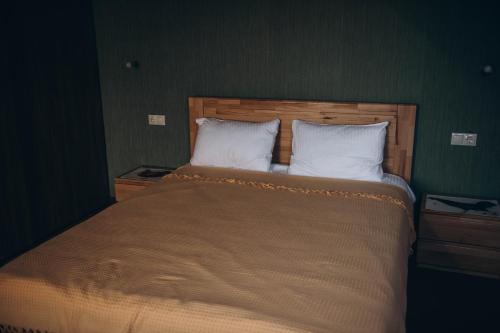 a bedroom with a large bed with two pillows at Дбайлива Ципа in Mizhhirʼʼya