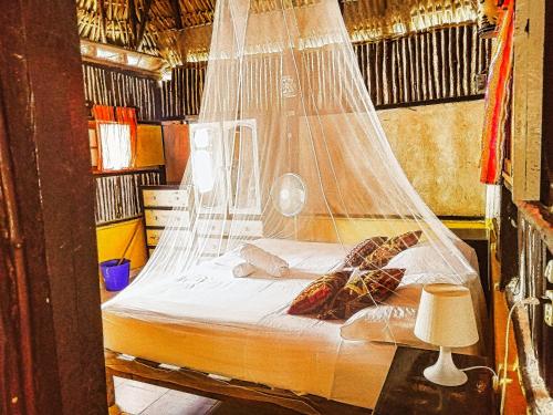 een bed met een net in een kamer bij Beachfront Casa Maya Lodge in El Cuyo