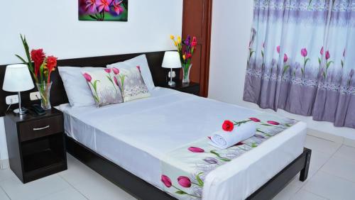 een slaapkamer met een bed met bloemen erop bij Residencial Lago Verde in Tarapoto