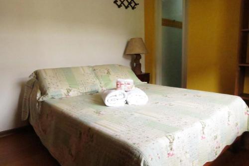 a bed with two hello kitty towels on it at Pousada Toca das Bromelias in Campos do Jordão