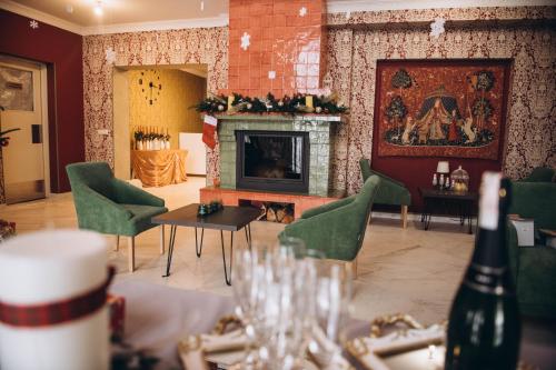 a living room with a fireplace and a table with wine glasses at Дбайлива Ципа in Mizhhirʼʼya