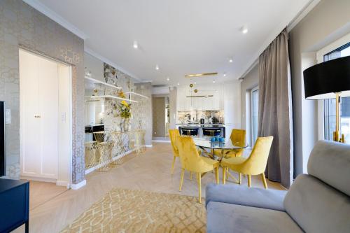 ein Esszimmer und eine Küche mit einem Tisch und gelben Stühlen in der Unterkunft About Art Apartments in Breslau