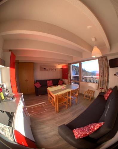 een woonkamer met een bank en een tafel bij Location appartement Chamrousse 1650 - Superbe vue in Chamrousse