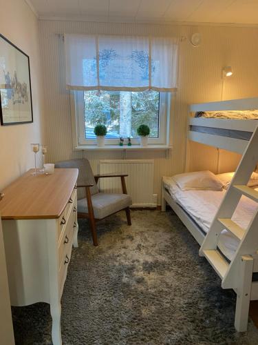 a bedroom with a bunk bed and a desk at Modern Lapland Cottage with Outdoor Sauna & BBQ Hut in Slagnäs
