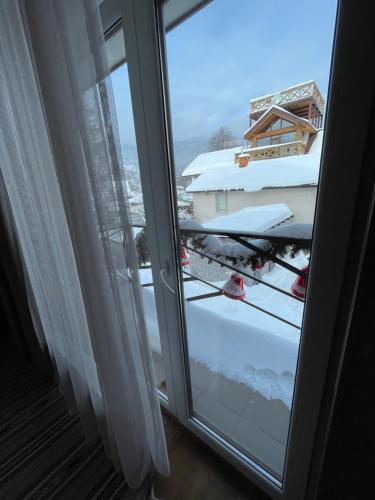 a sliding glass door with a view of a snow covered yard at Girske Povitria 2 in Yaremche