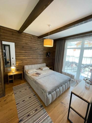 a bedroom with a bed and a wooden wall at Girske Povitria 2 in Yaremche