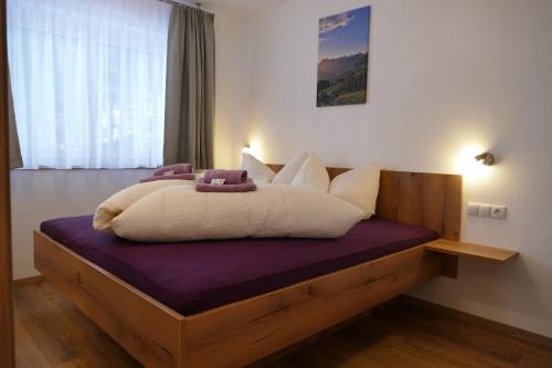 uma cama com almofadas brancas em cima em Bergliebe Apartments em Gerlosberg